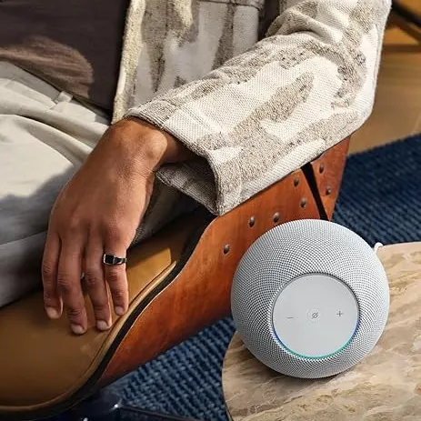 Altavoz Echo con más presencia junto a un sillón como ejemplo de compra para salón o estancia principal