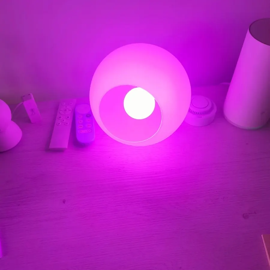 Bombilla Basics E27 regulable iluminando una mesita con luz rosa