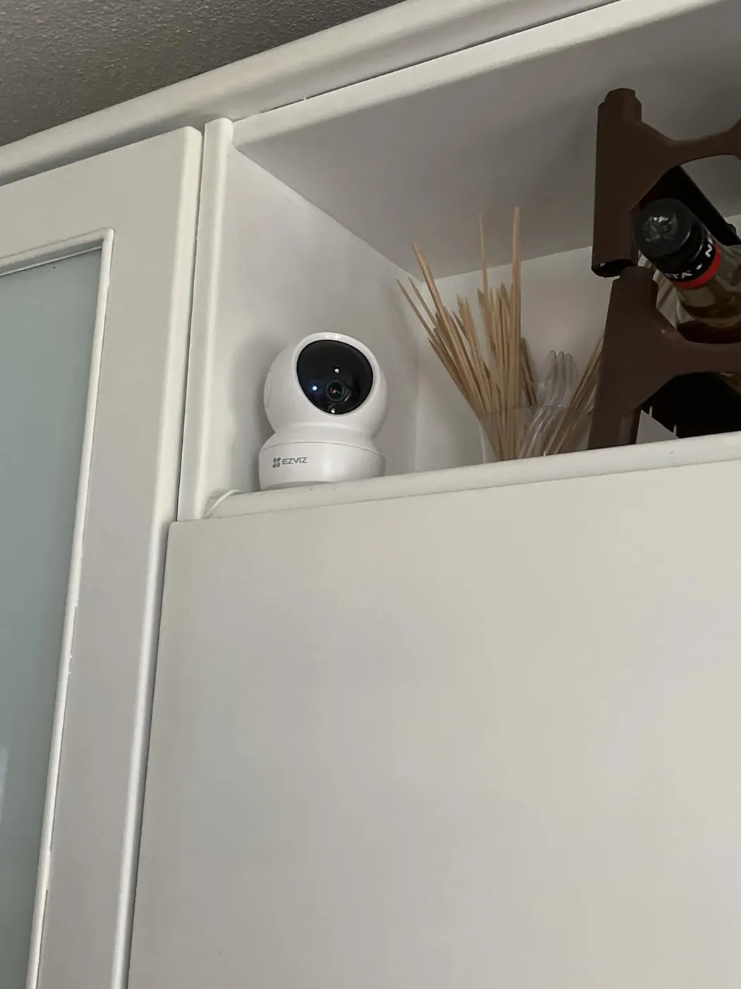 Cámara interior EZVIZ C6N colocada en alto sobre un mueble